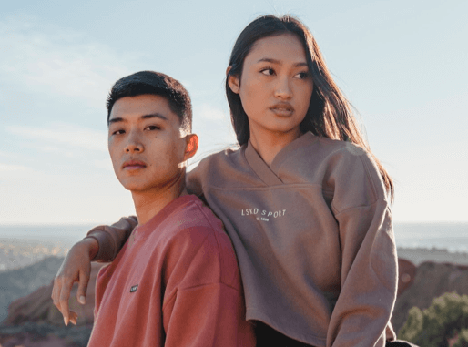 A man and woman wearing LSKD sweatshirts